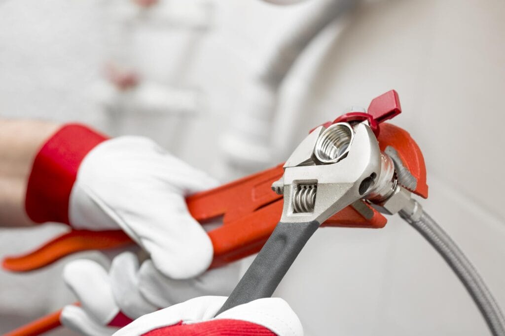 Plumber holding pipe wrenches for an emergency repair in Chandler