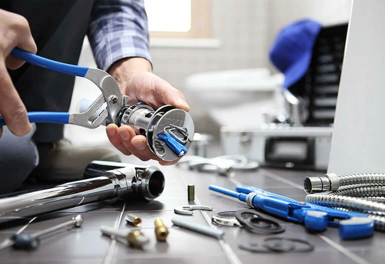 Technician repairing a plumbing fixture with professional tools in Chandler