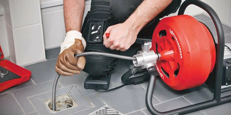 Plumber using a drain-cleaning machine in Chandler
