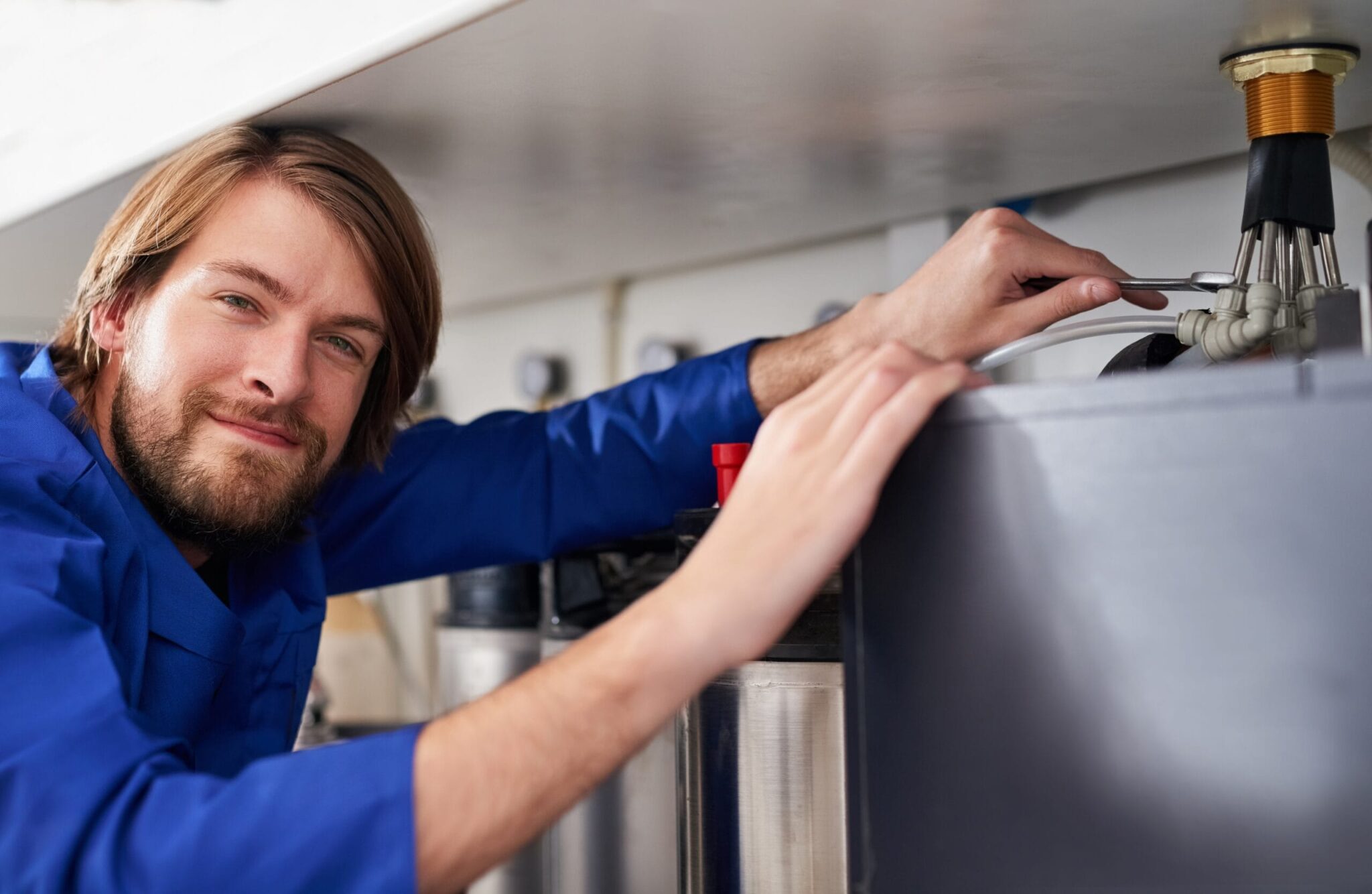 Technician servicing a residential water heater tank in Chandler